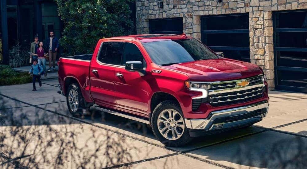 A red 2024 Chevy Silverado 1500 Z71 parked near a house.
