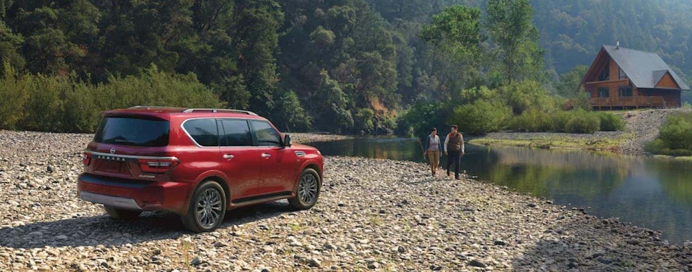 A red 2022 Nissan Armada from the side while off-road.