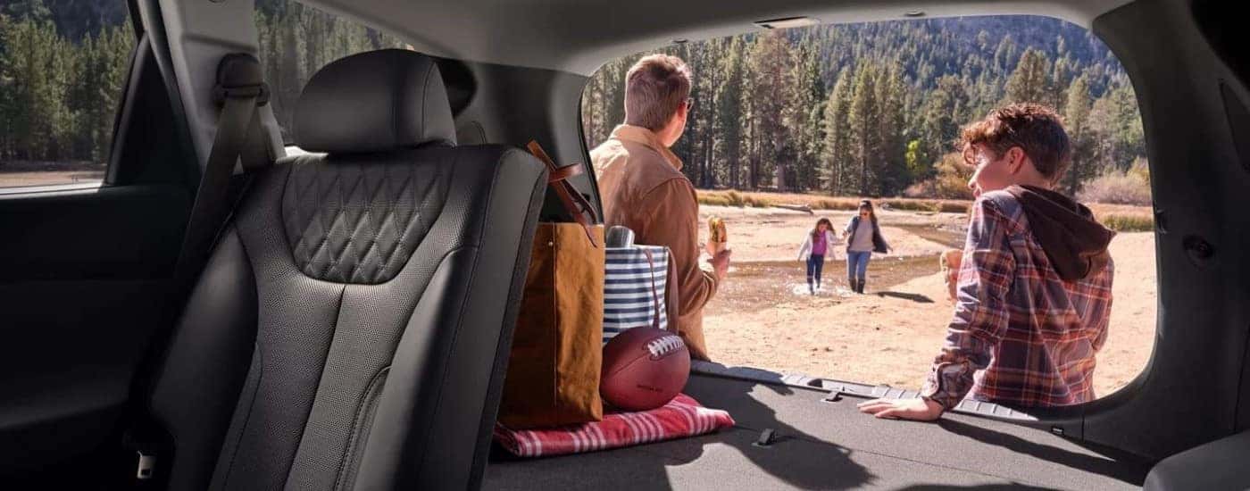 Family sitting in the rear cargo area of a used 2023 Hyundai Santa Fe PHEV