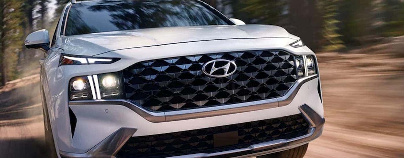 A white used 2023 Hyundai Santa Fe driving off-road