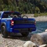 A blue 2025 Nissan Frontier parked off-road near a lake