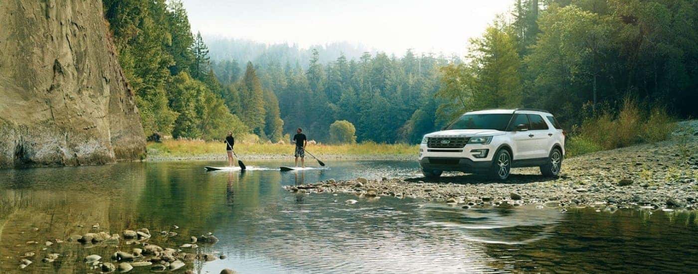 A white 2017 Ford Explorer parked near people paddle boarding.