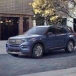 A used blue 2020 Ford Explorer for sale driving in a city.