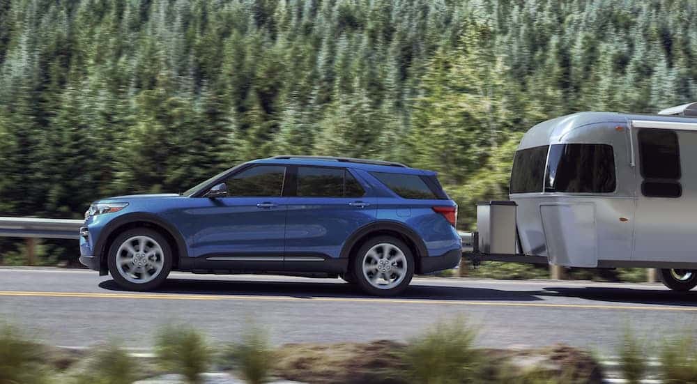 A blue 2020 Ford Explorer towing a trailer.