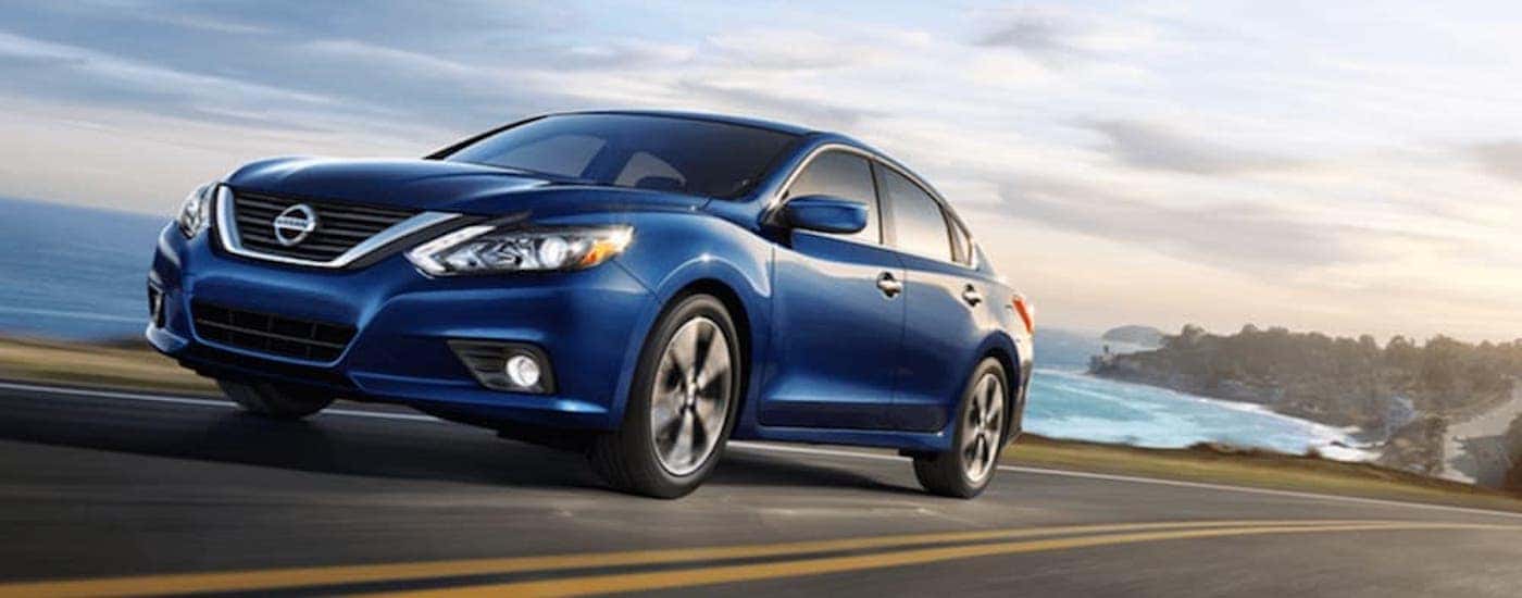 A blue used 2018 Nissan Altima driving down a highway