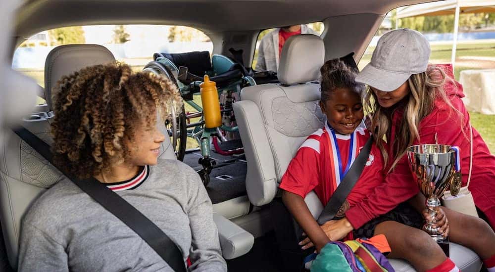 A parent buckles their children into the backseat of their 2026 Ford Explorer.