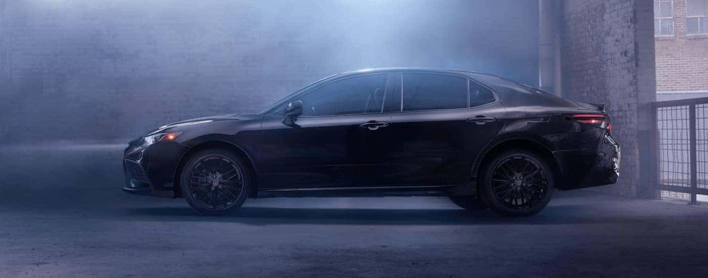 A black 2021 Toyota Camry for sale from the side.