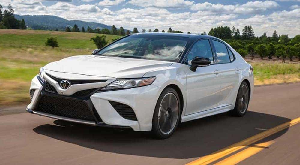 White 2018 Toyota Camry for sale driving down the road.