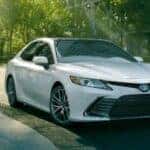 A white 2024 Toyota Camry for sale parked in a city.