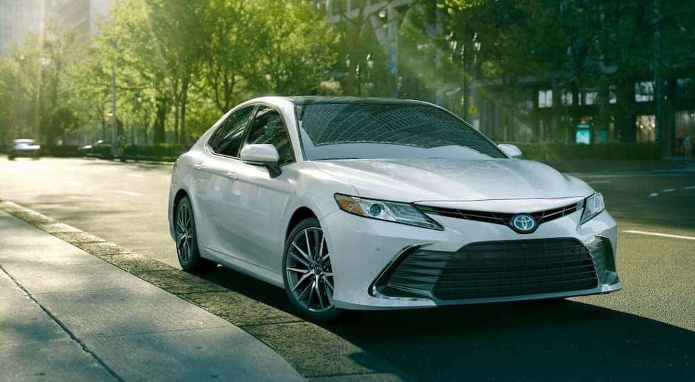 A white 2024 Toyota Camry for sale parked in a city.