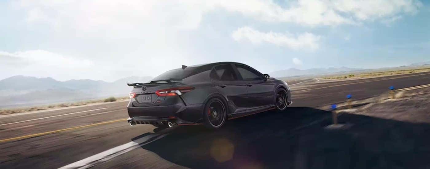 A black 2023 Toyota Camry TRD from the rear at an angle.