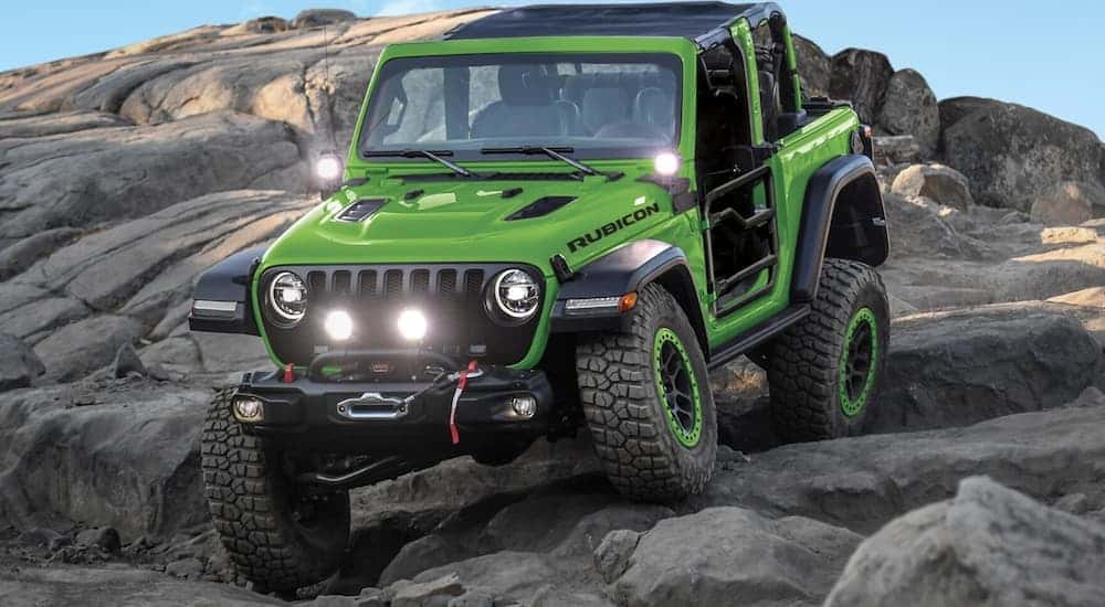 A green 2018 Jeep Wrangler JL off-roading.