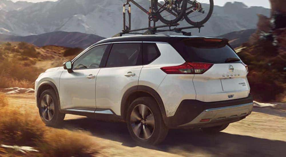 White 2021 Nissan Rogue with a bike on the roof