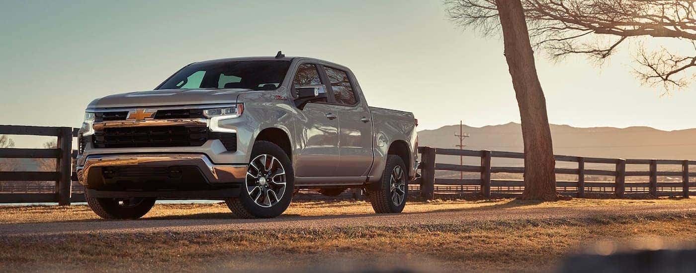 Silver 2023 Chevy Silverado 1500 Z71 parked by a fence