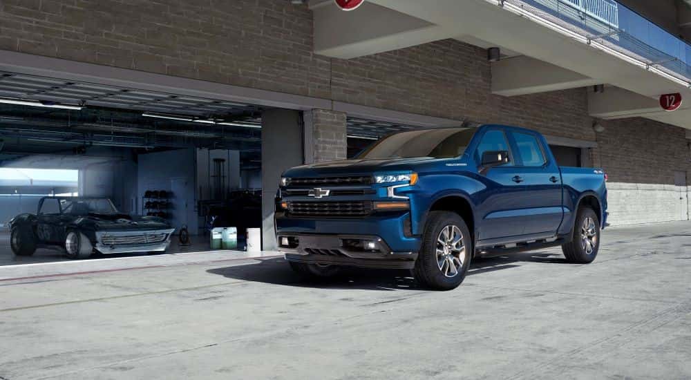 A blue 2019 Chevy Silverado 1500 parked near a garage.