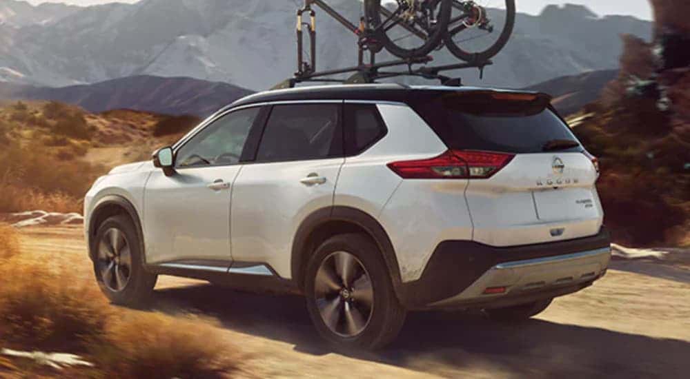 White 2021 Nissan Rogue with a bike on the roof