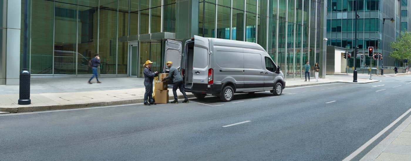 A grey 2024 Ford Transit from the rear after leaving a dealer with used vans for sale.