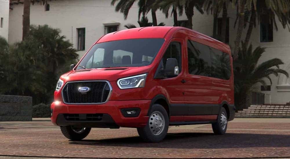 A red 2024 Ford Transit Van parked during the day.
