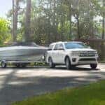 A white 2023 Ford Expedition towing a boat