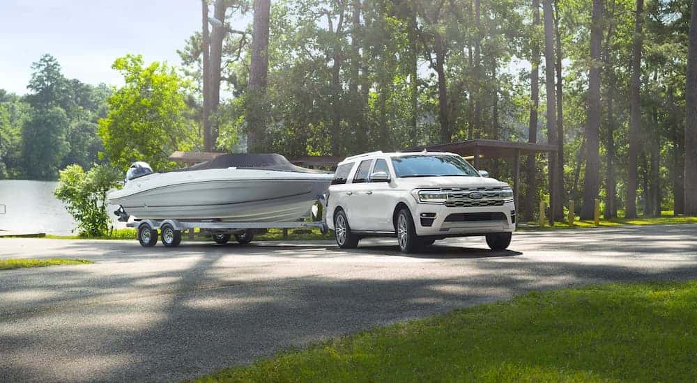 A white 2023 Ford Expedition towing a boat