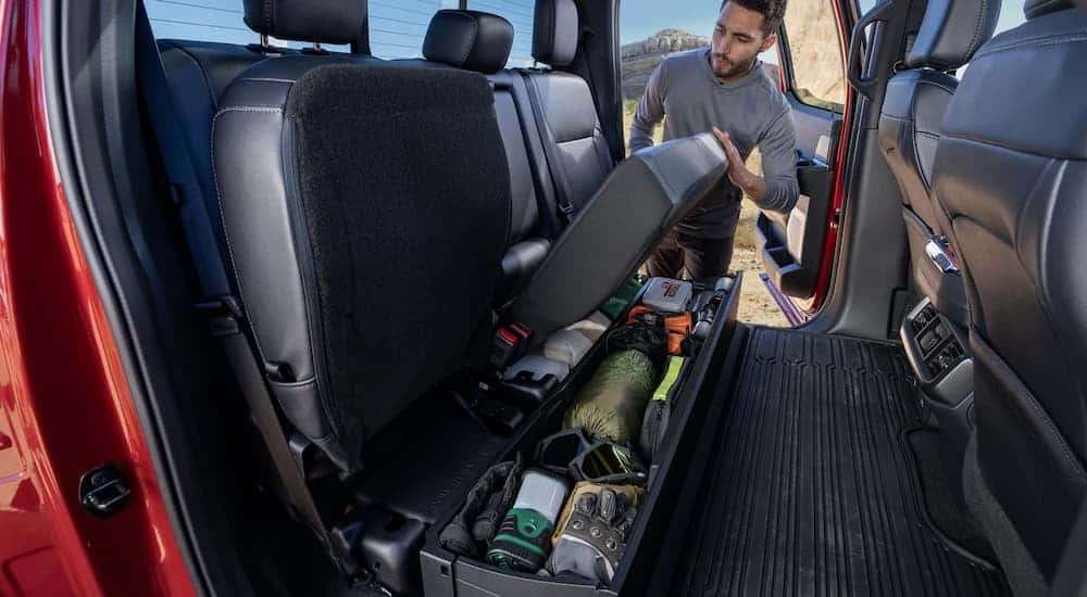 Man grabbing gear from the under seat storage in a 2024 Ford F-150