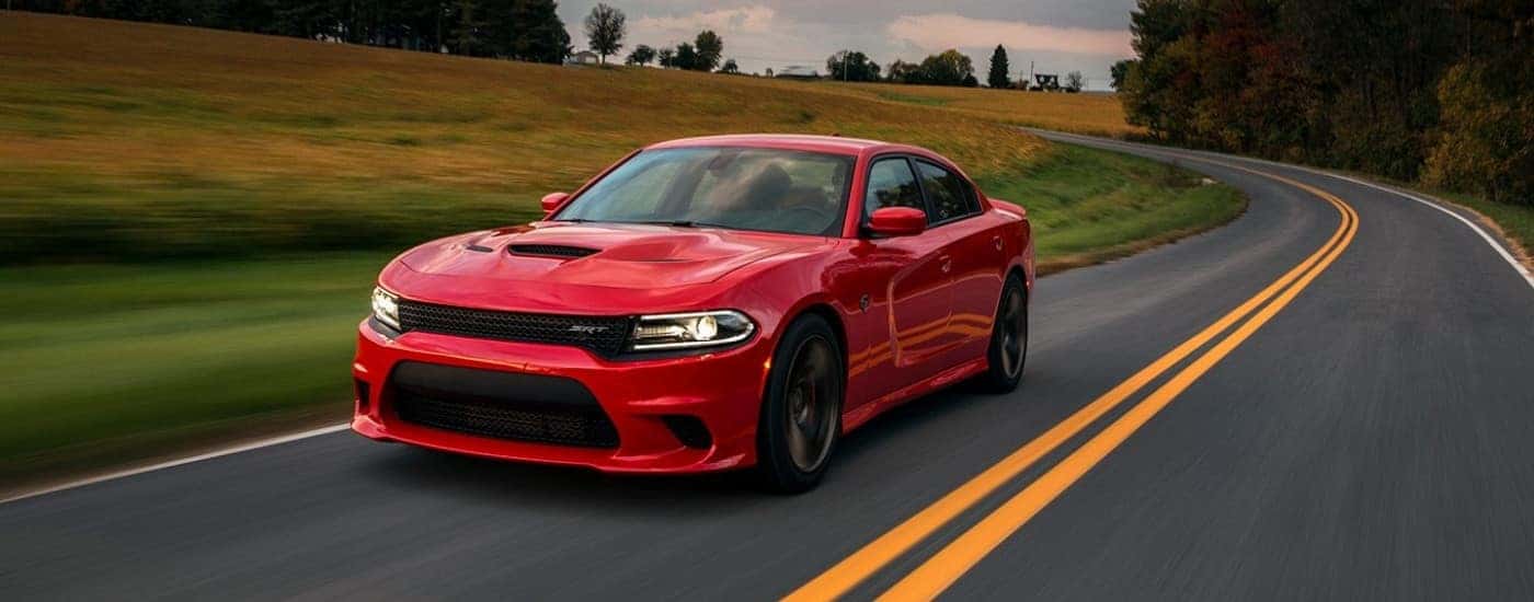Red 2015 Dodge Charger SRT driving on an open road