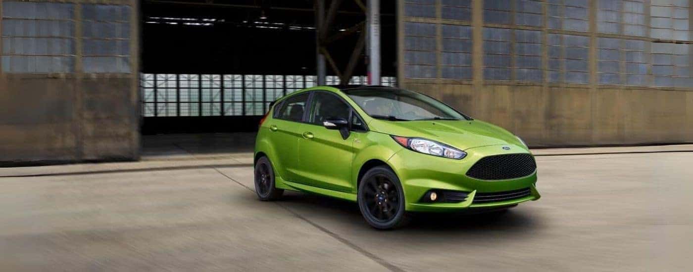 A lime green 2018 Ford Fiesta driving to a used car dealer near Clinton.