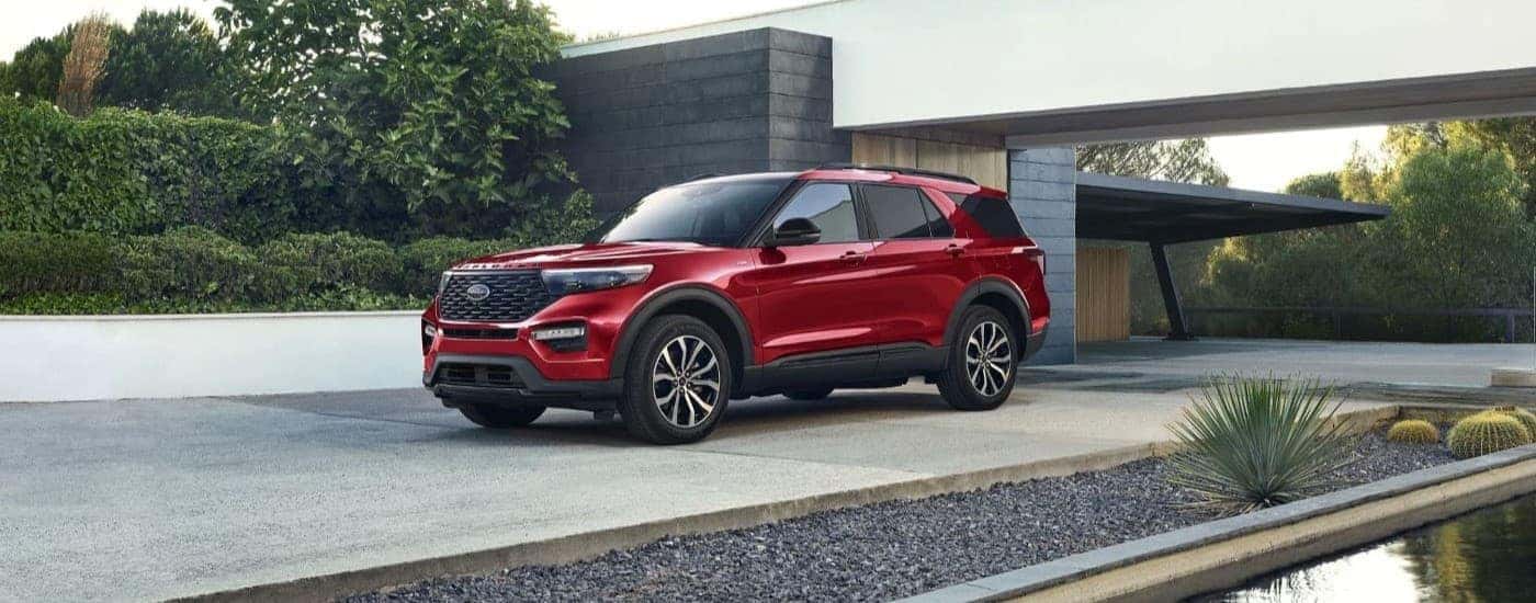 A red 2023 Ford Explorer ST-Line is shown parked on driveway.