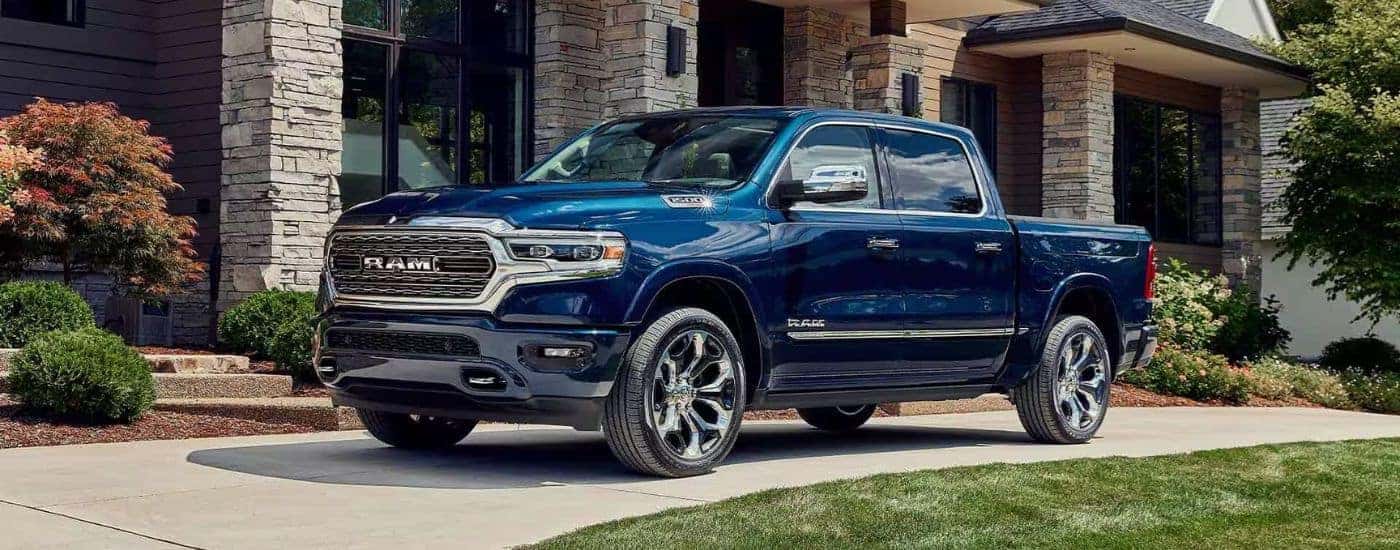 Blue 2023 Ram 1500 Limited parked outside a house.