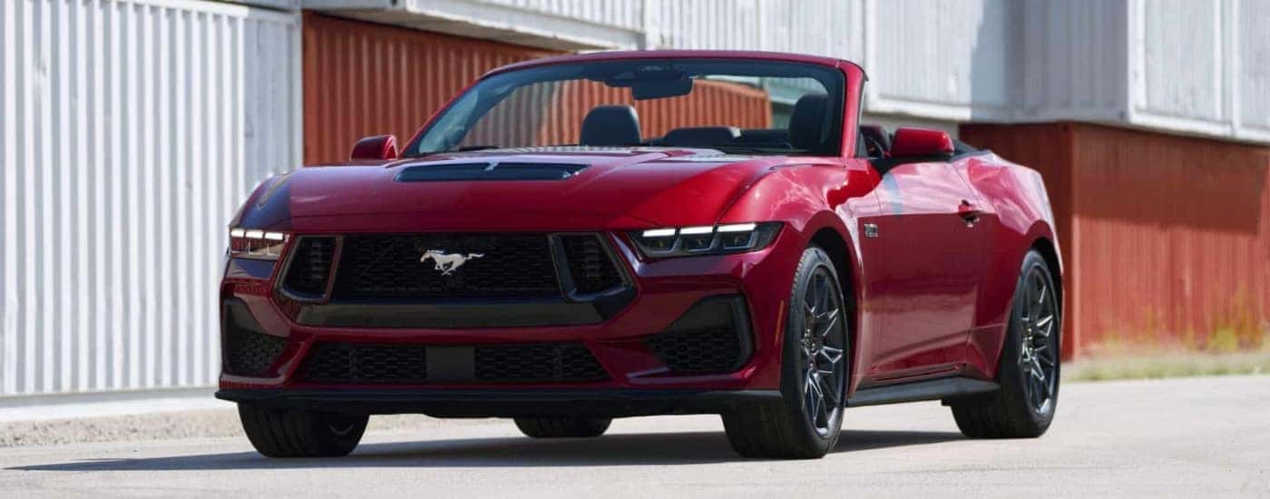 Red 2024 Ford Mustang GT parked near shipping containers