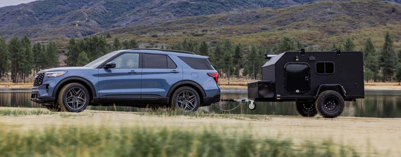 Blue 2026 Ford Explorer towing a camper