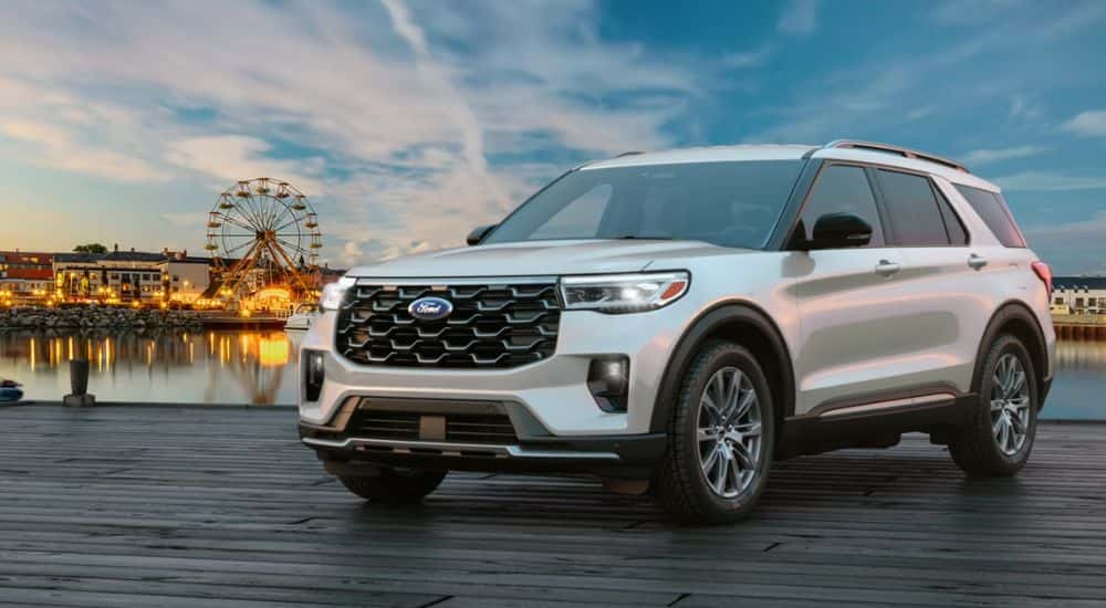 Silver 2026 Ford Explorer parked on a pier with a Ferris wheel in the background