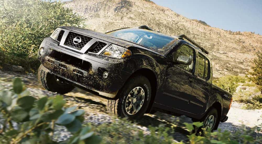 Black 2021 Nissan Titan driving up a trail.
