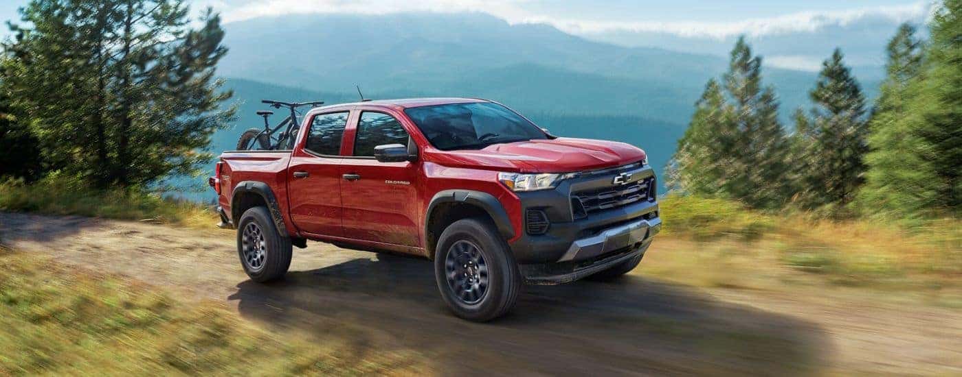 Red 2023 Chevy Colorado Trail Boss on a trail in the mountains.
