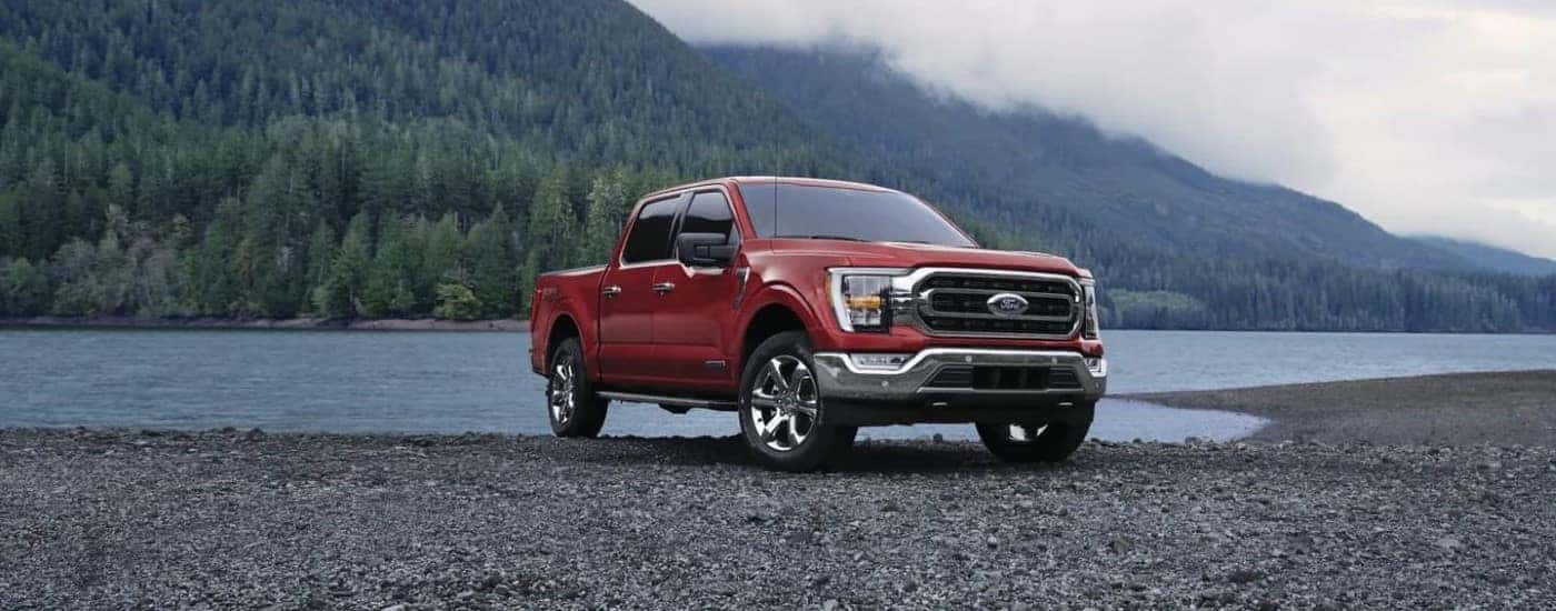 Red 2023 Ford F-150 parked on the edge of a lake