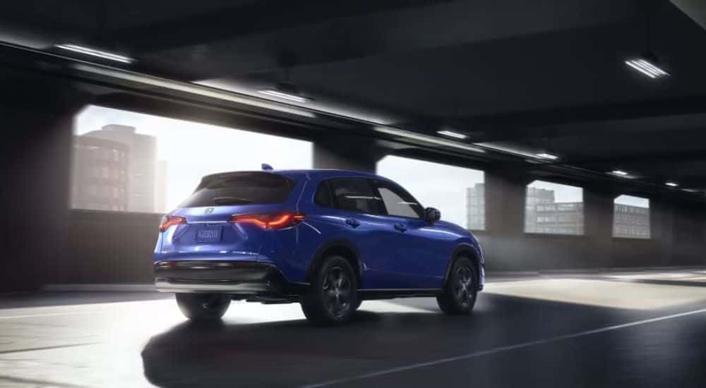 Blue 2023 Honda HR-V driving through a parking garage.
