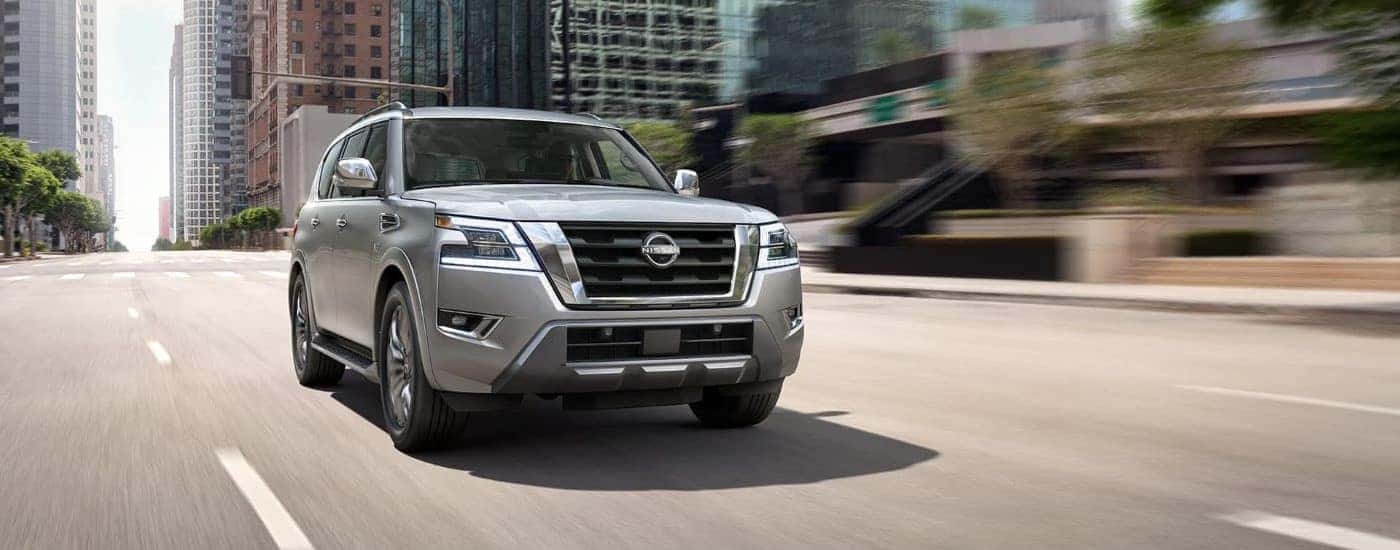 Silver 2023 Nissan Armada driving through the city streets.