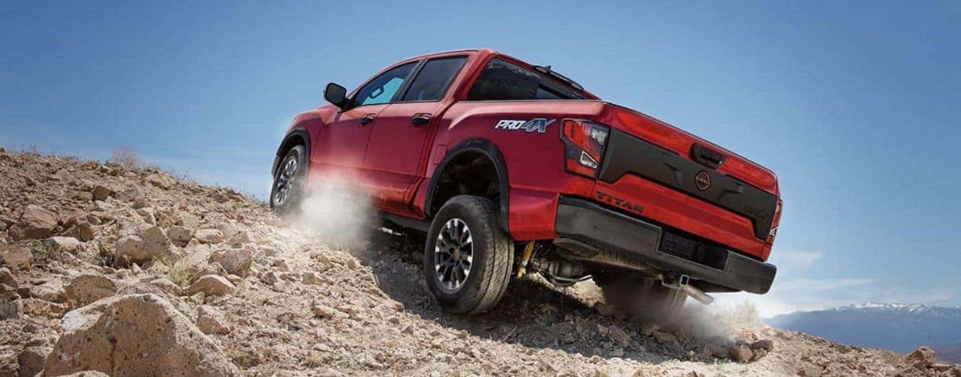 Red 2024 Nissan Titan Pro 4 driving on a dirt road.