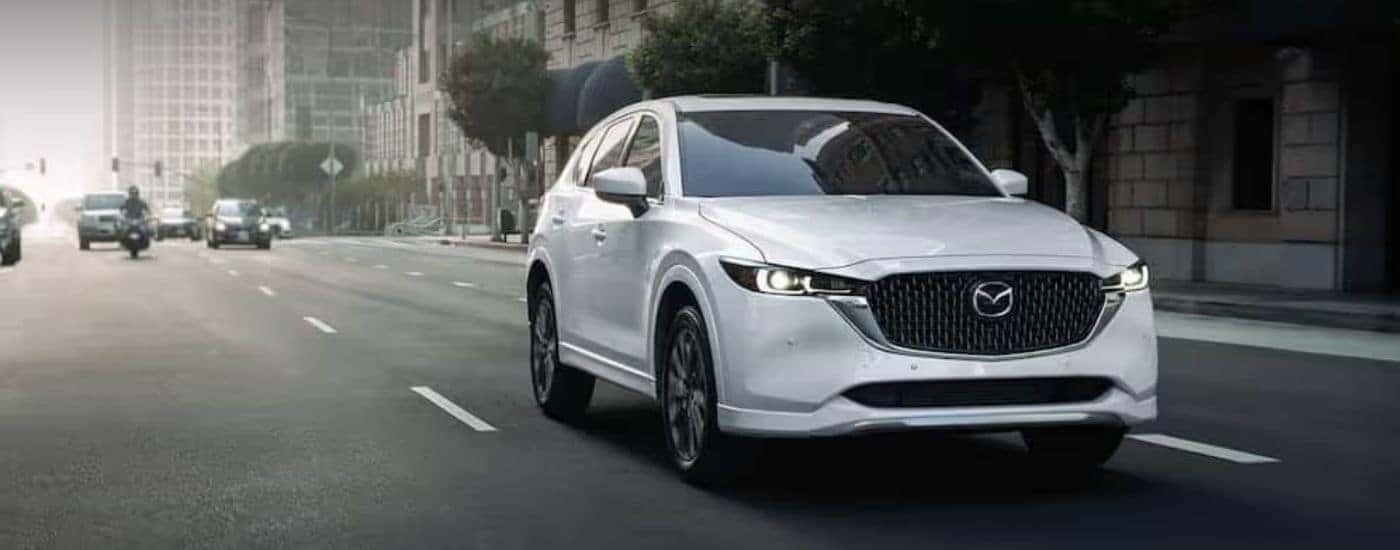 A white 2022 Mazda CX-5 driving in front of other vehicles.