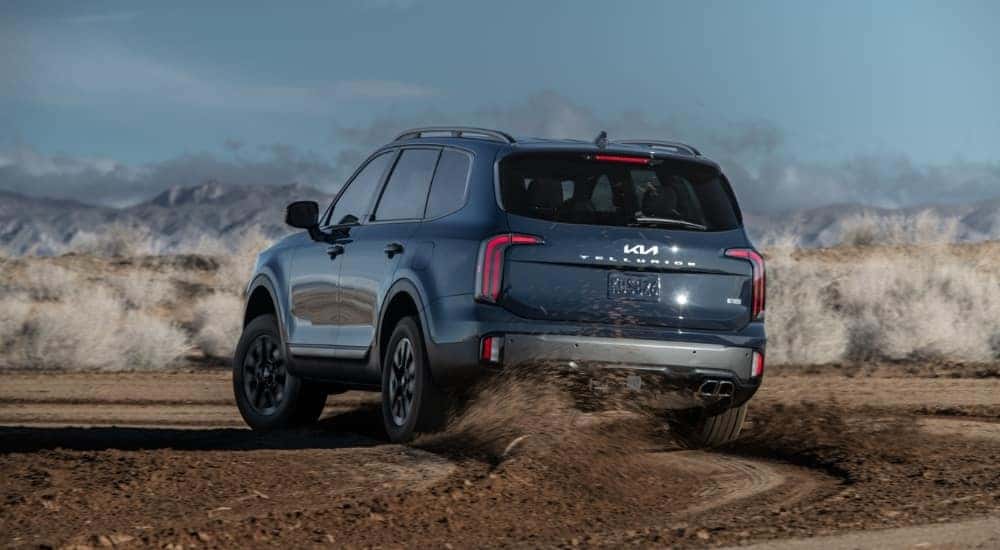 Blue 2023 Kia Telluride X Pro drifting off road.