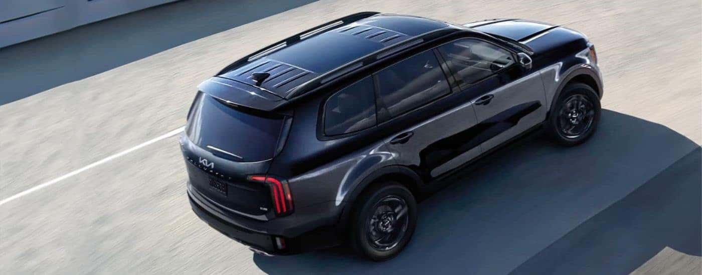 Black 2024 Kia Telluride driving down a freeway from above