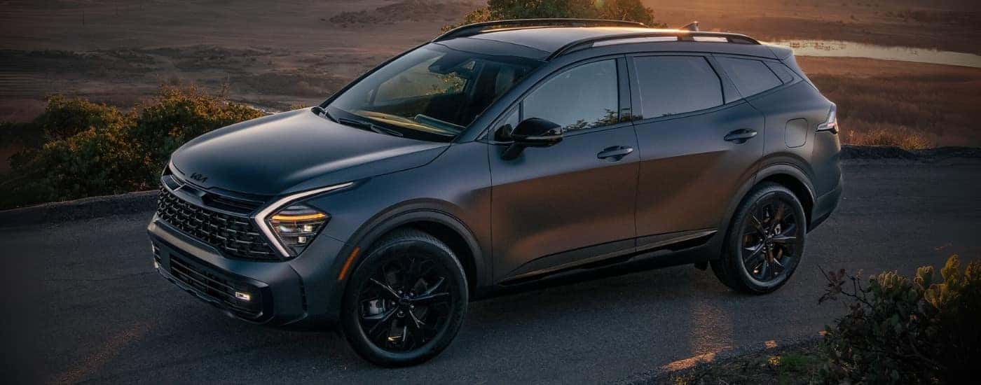 Grey 2025 Kia Sportage driving down an open road
