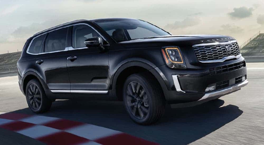 A black 2020 Kia Telluride shown driving on a race track.