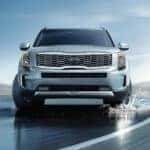 A silver 2020 Kia Telluride driving on a wet shoreline.