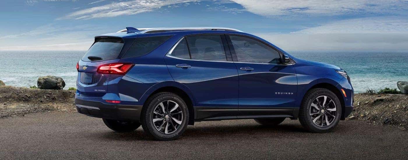 A blue 2023 Chevy Equinox parked by ocean.