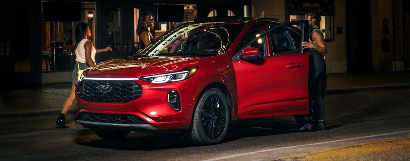 Friends entering a red 2023 Ford Escape ST-Line Elite.