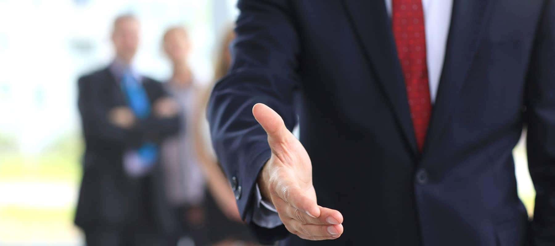 Person in suit extending hand for handshake