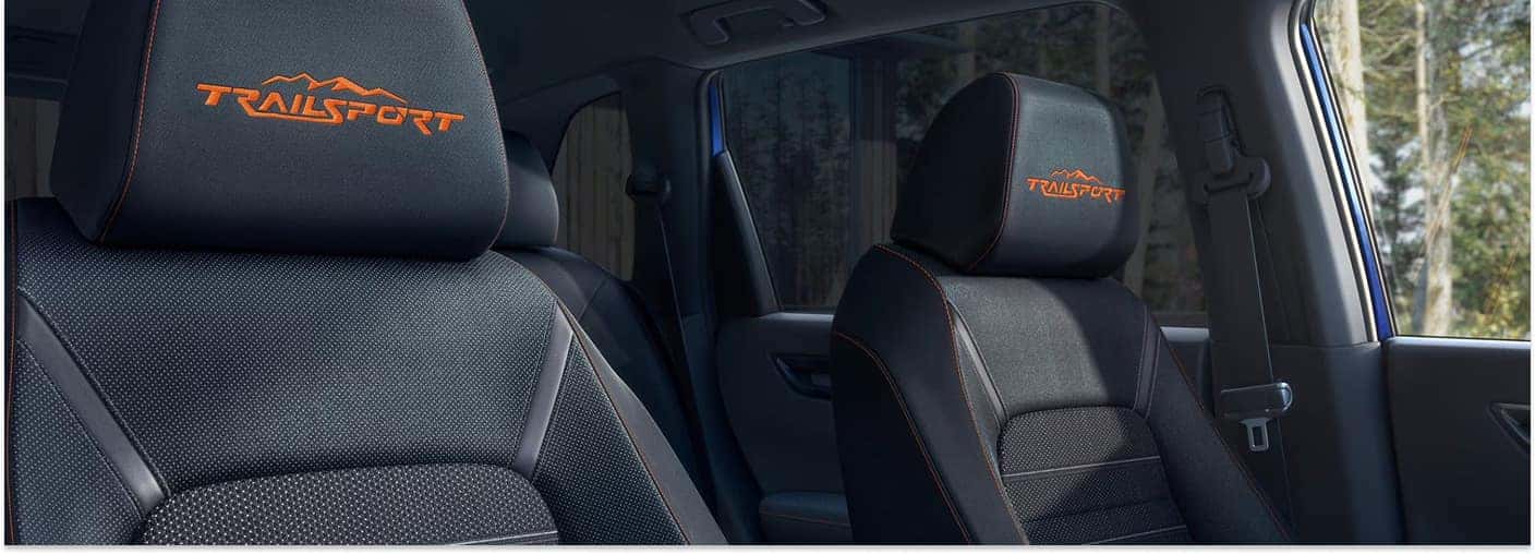 Interior of a 2026 Honda CR-V TrailSport Hybrid showing front seats with orange embroidered TrailSport logos.