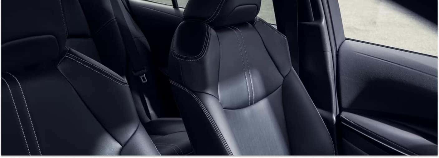 Black leather front seats with white contrast stitching inside a 2026 Toyota Corolla.