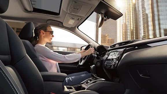 2022 nissan rogue sport with driver seen from passenger seat in daytime using eco mode